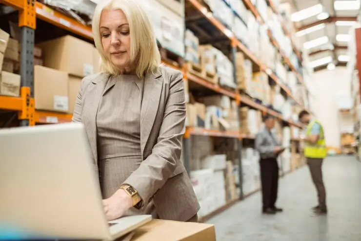 Employee uses inventory tracking software in warehouse.